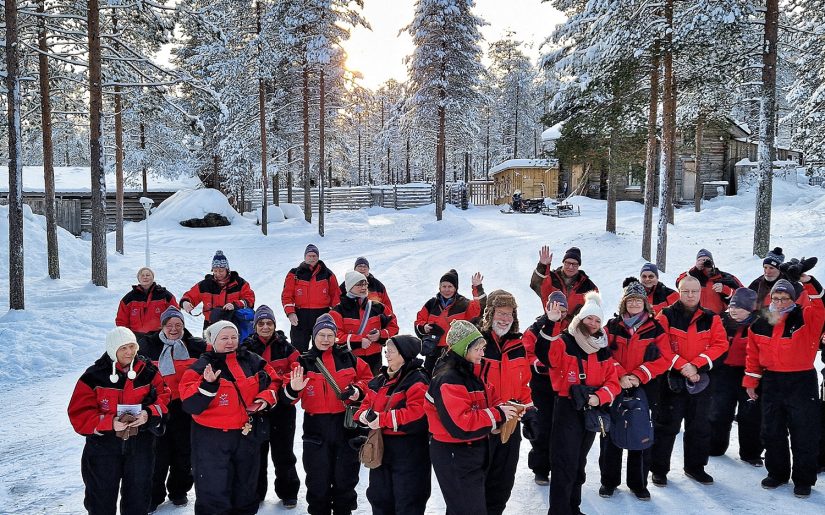 Die Reisefamilie von Peters-Reisen im verschneiten Wald von Finnlands Lappland.