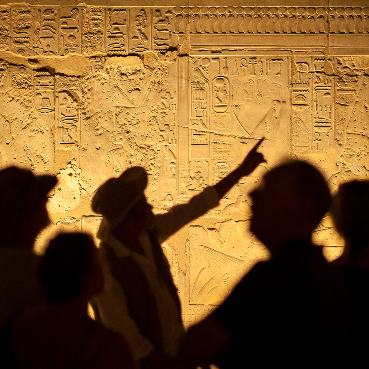 Ein Reiseführer zeigt auf alte Antike Schriftzeichen